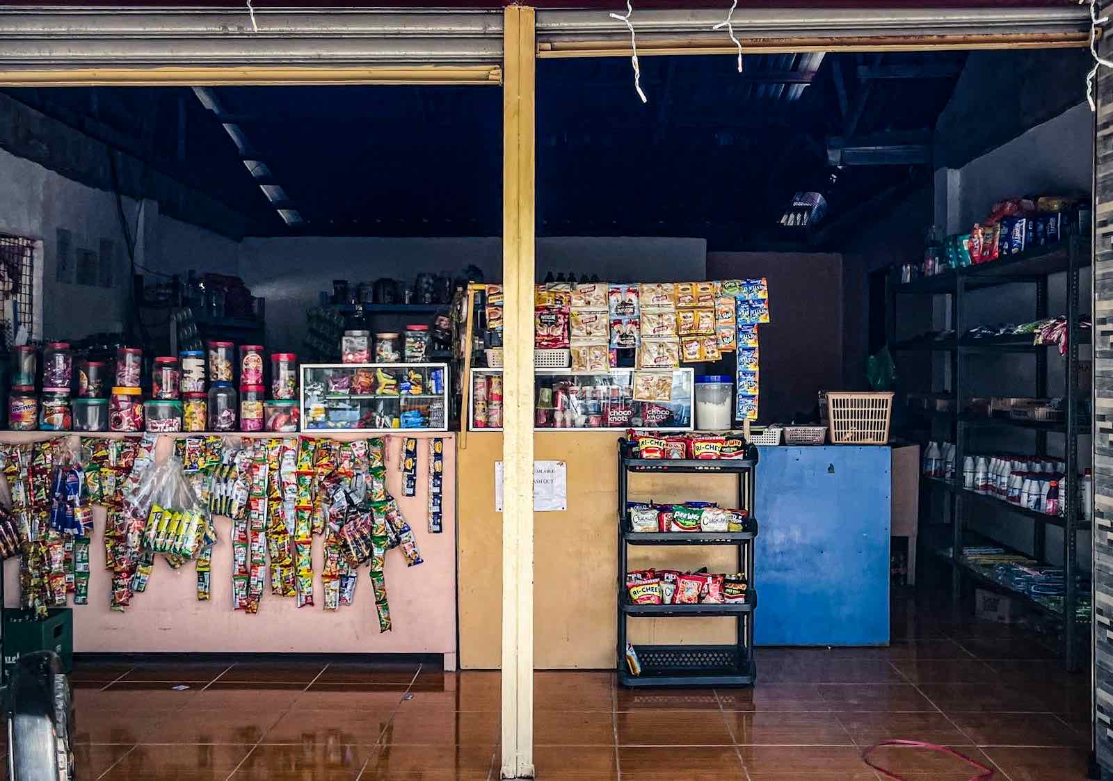 Interior of a small neighborhood shop with shelves of everyday goods.